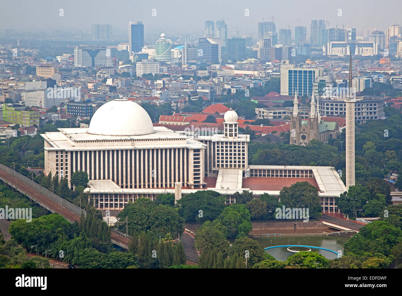 Lo smog che gravano su di Giacarta e vista sulla Moschea Istiqlal / Masjid Istiqlal, più grande moschea in Indonesia e nel Sud Est asiatico Foto Stock
