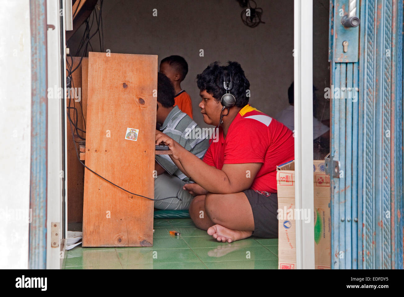 Adolescente indonesiano navigando in internet café / cybercafé nella capitale Giacarta, Java, Indonesia Foto Stock