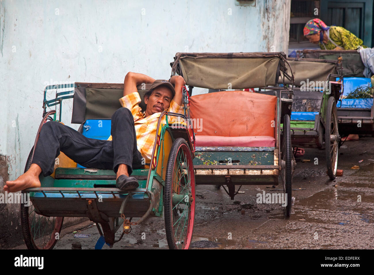 Indonesiano driver becak in attesa per i clienti nel suo risciò ciclo di Giacarta, Java, Indonesia Foto Stock