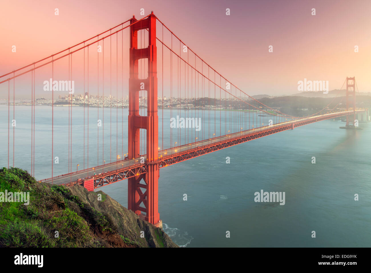 Il Golden Gate bridge di sospensione con lo skyline della città in background in un giorno di nebbia, San Francisco, California, Stati Uniti d'America Foto Stock