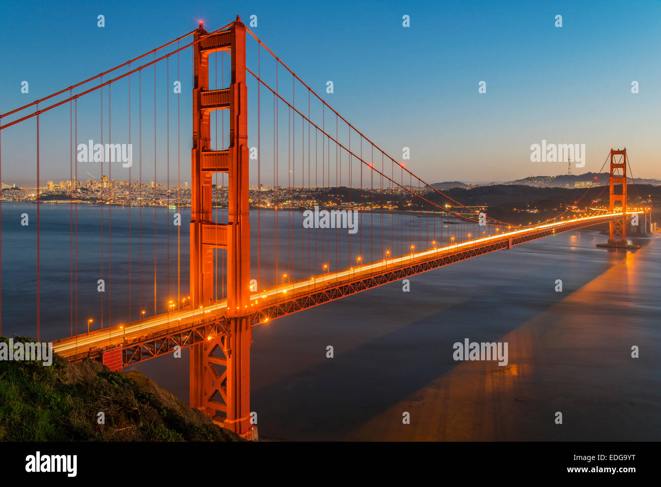 Vista notturna del Golden Gate bridge di sospensione con lo skyline della città in background, San Francisco, California, Stati Uniti d'America Foto Stock