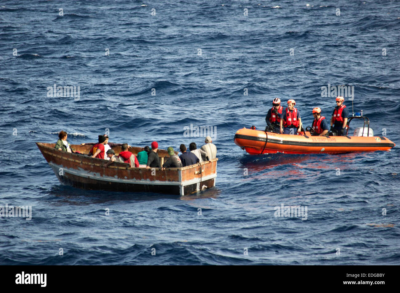 Membri della US Coast Guard Cutter Cavaliere approccio isola una barca con 12 emigranti cubani 30 Dicembre 2014 a sud-ovest di Key West, Florida. Gli Stati Uniti Coast Guard segnala che il numero dei cubani prelevati in mare nel tentativo di raggiungere gli Stati Uniti è cresciuto da quando il Presidente Barack Obama ha annunciato i piani per il ripristino delle relazioni diplomatiche con l'Avana. Foto Stock