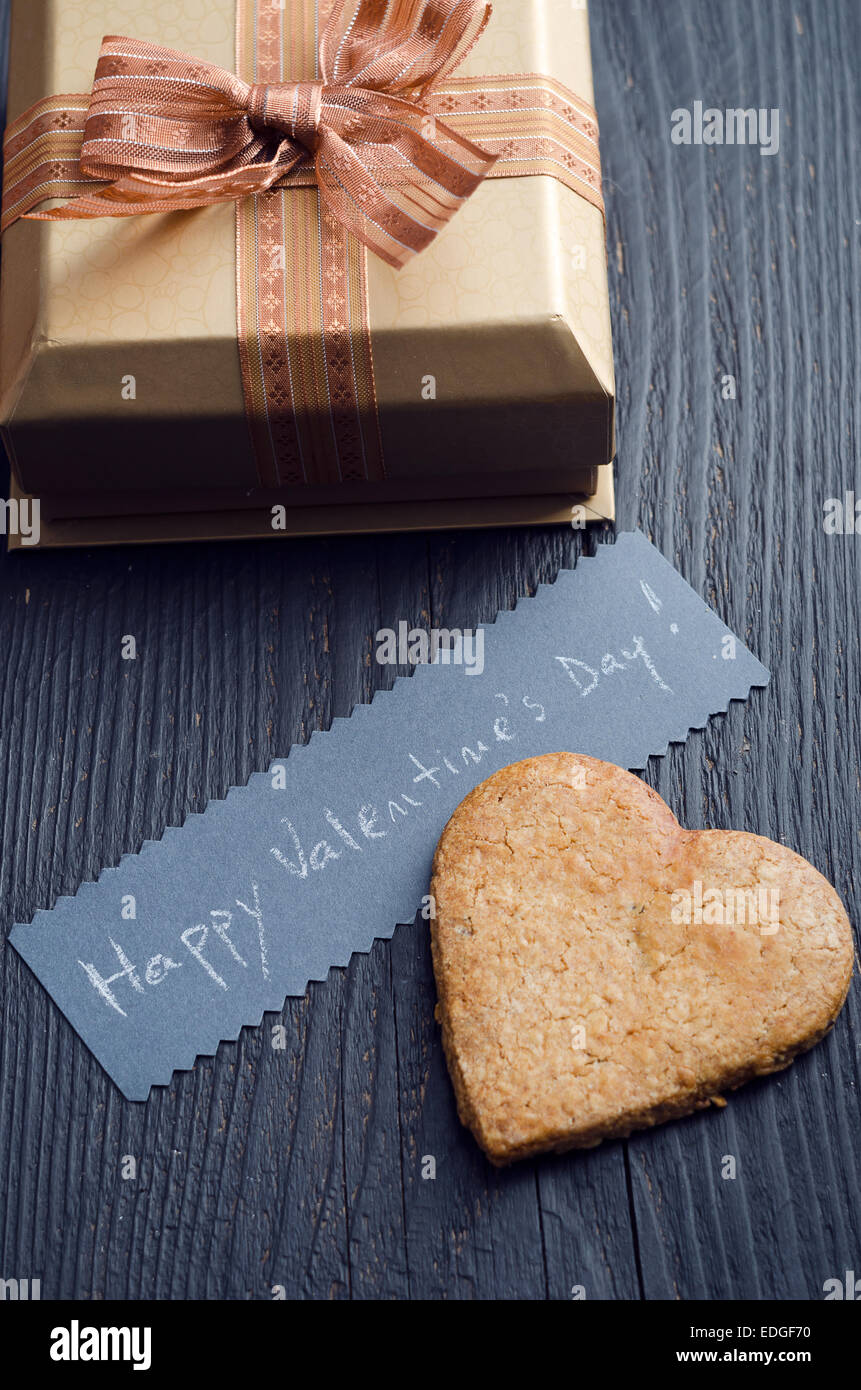 Tino forma cookie, confezione regalo e una scheda manoscritta con 'felice il giorno di San Valentino! ' Testo Foto Stock