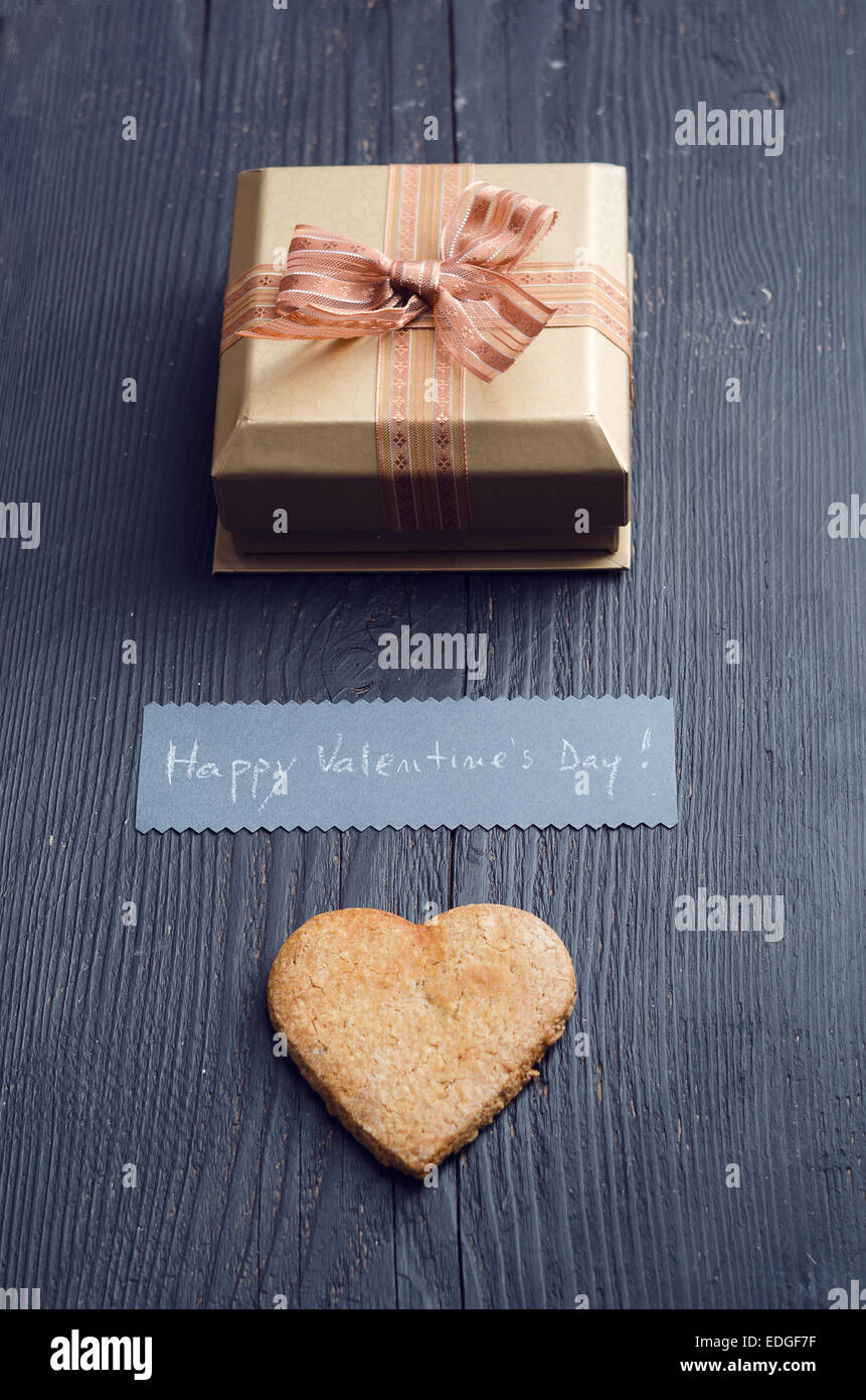 Tino forma cookie, confezione regalo e una scheda manoscritta con 'felice il giorno di San Valentino! ' Testo Foto Stock