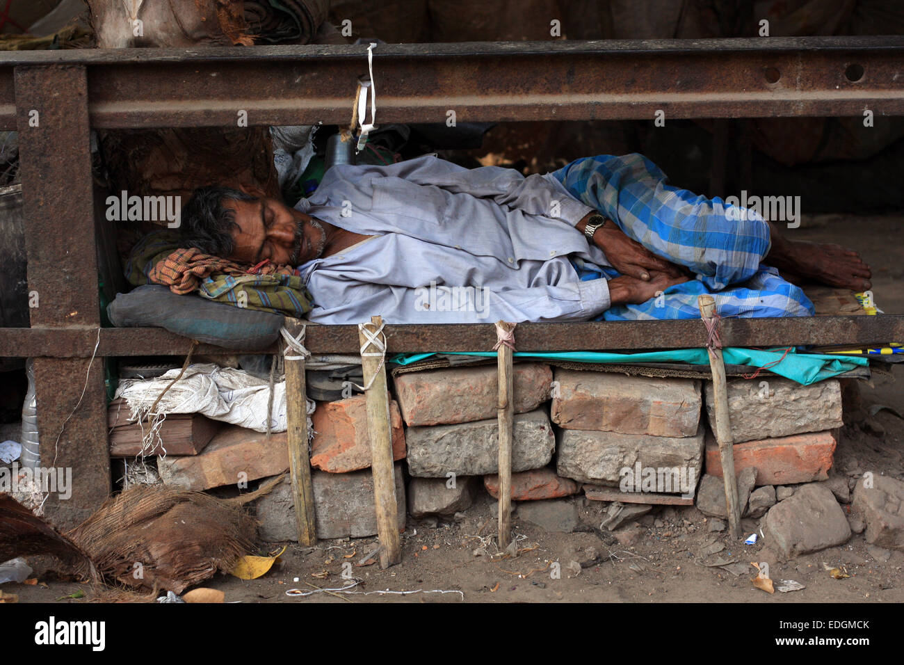 Senzatetto indian uomo addormentato accanto alla strada in un letto ... Un letto di fortuna