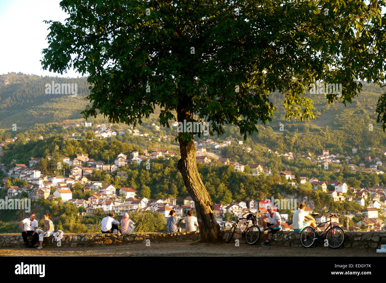 Le persone si radunano sulla cima di una collina a guardare il tramonto sopra Sarajevo. Foto Stock