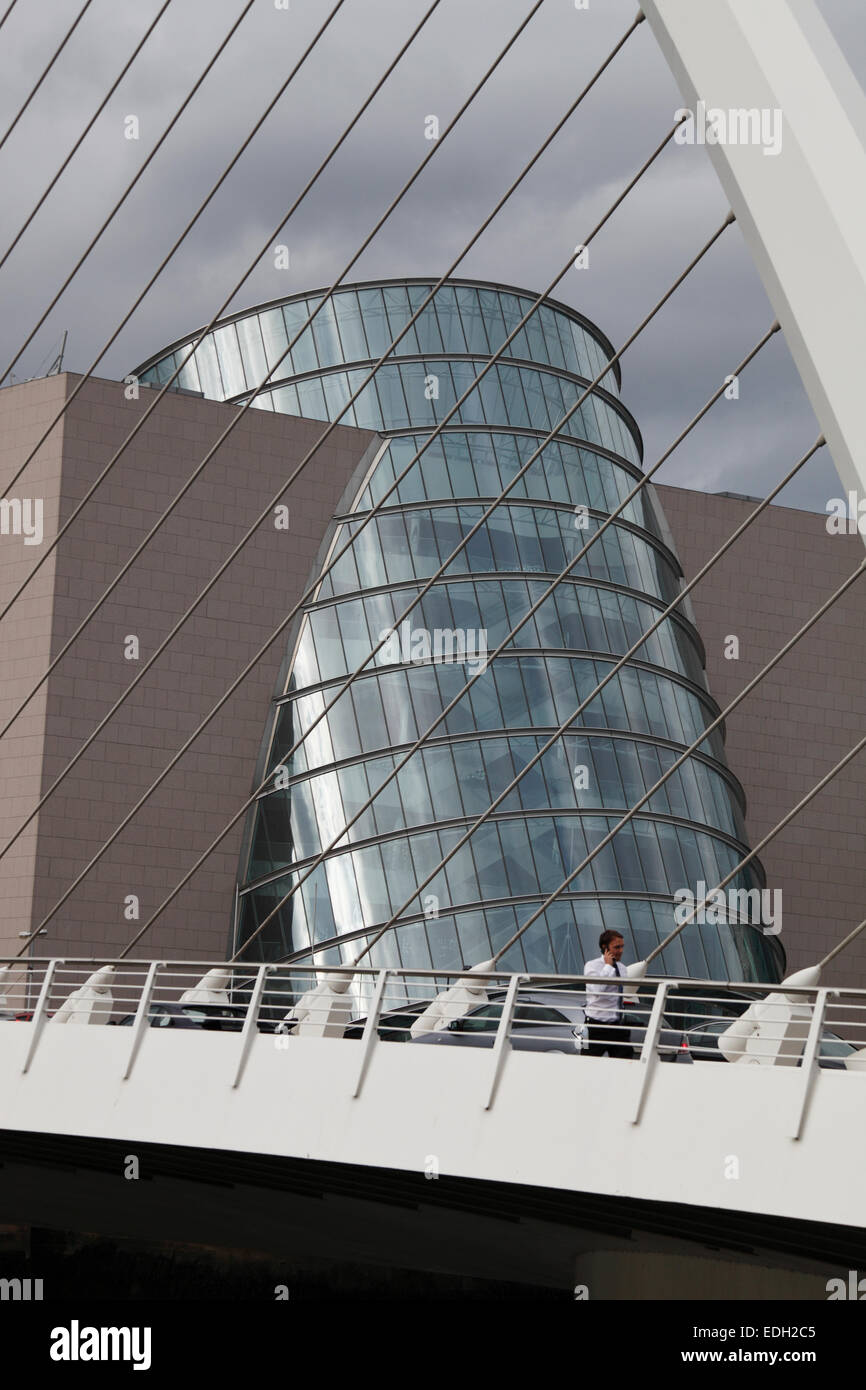 Uomo d affari con il cellulare su Samuel Beckett Bridge e il centro congressi sulla Spencer Dock a Dublino Foto Stock