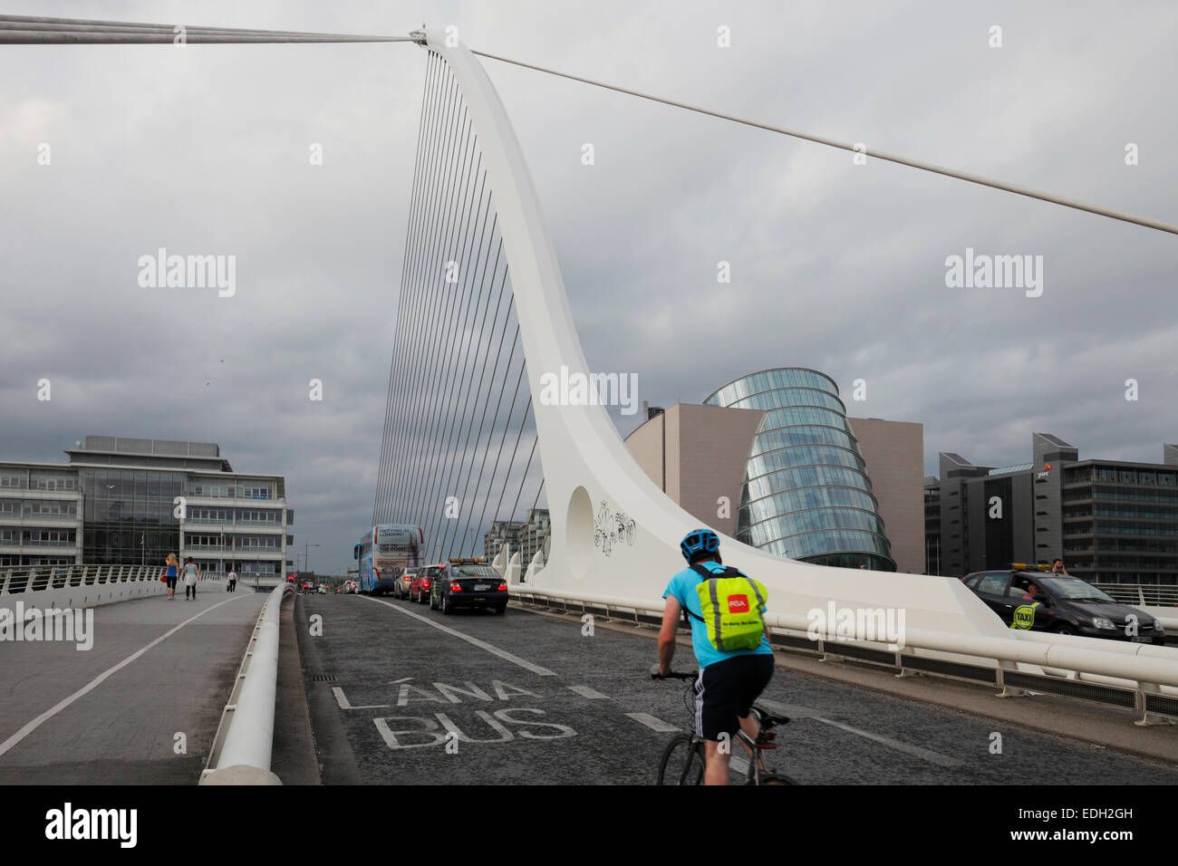 Biker su Samuel Beckett ponte che attraversa il fiume Liffey e il centro congressi sulla Spencer Dock a Dublino Foto Stock