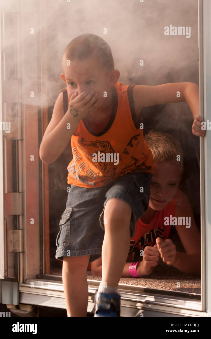 I bambini in uscita una piena di fumo suvive vivo sala del rimorchio Foto Stock