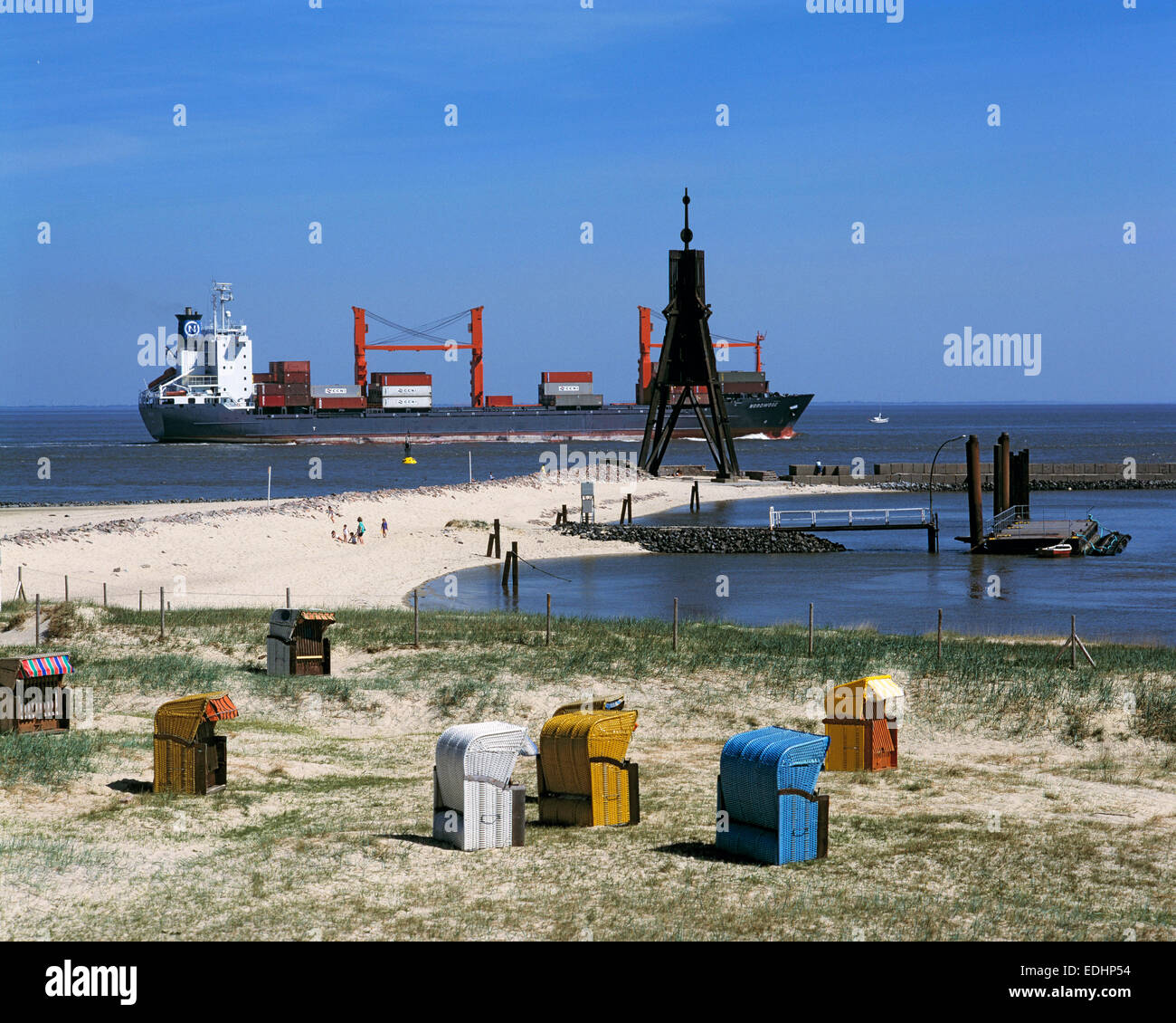 Kugelbake als historisches Seezeichen fuer die Schifffahrt an der Elbemuendung in Cuxhaven, Nordsee, Bassa Sassonia, Strandkoerbe und Containerschiff Foto Stock