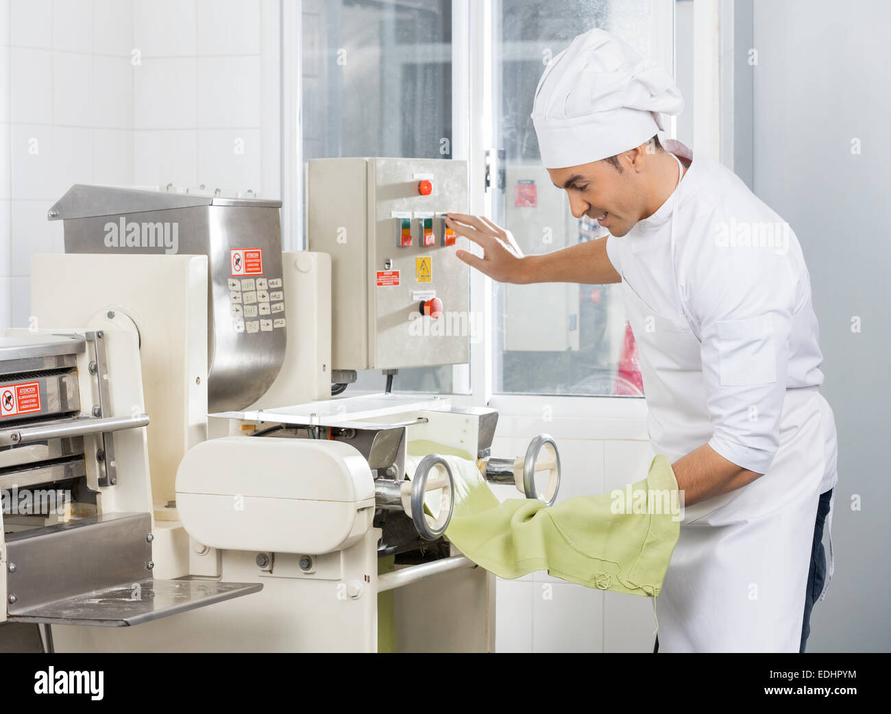 Lo chef sorridente spaghetti di funzionamento macchina per la pasta Foto Stock
