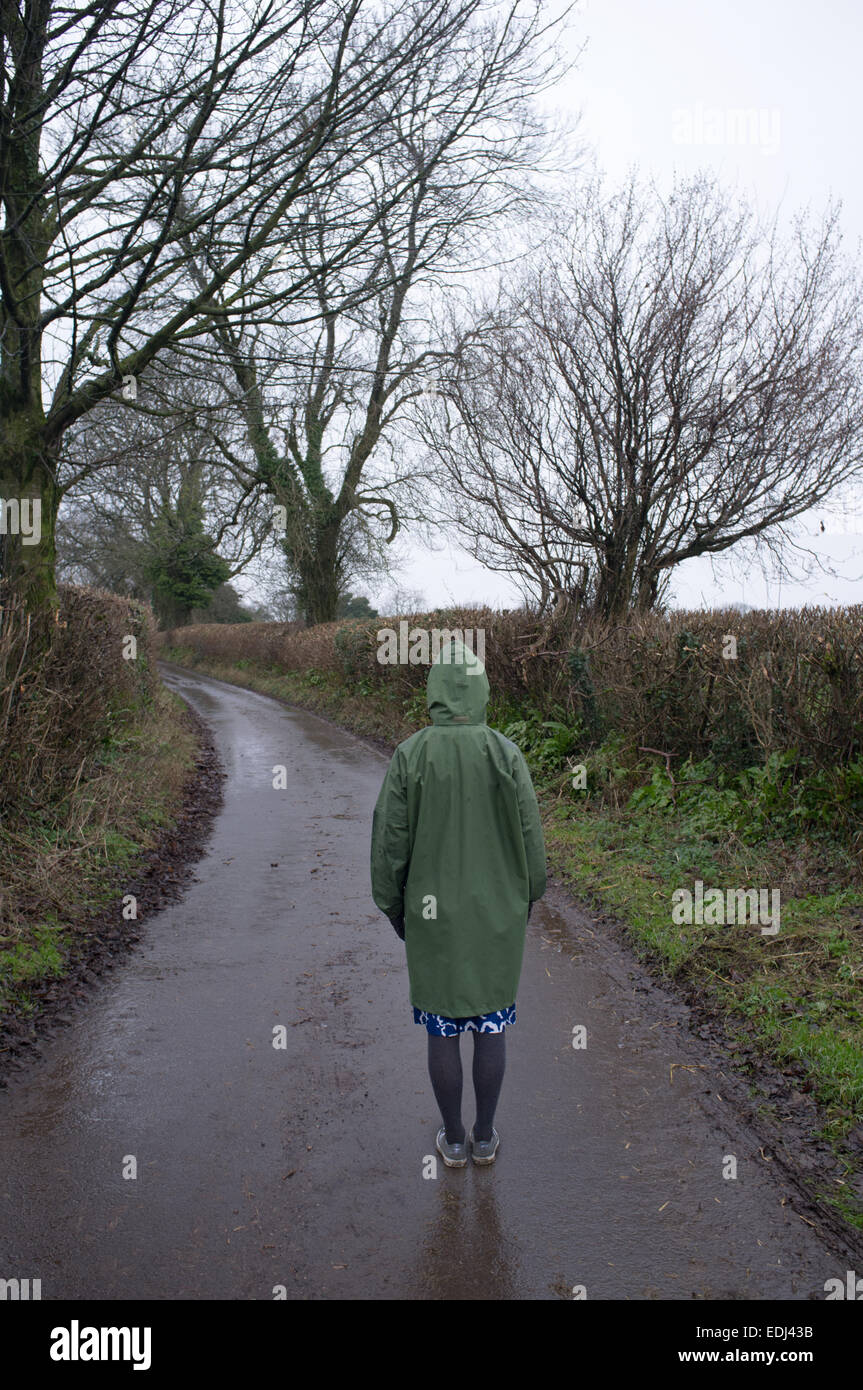 Una donna si erge su un vicolo del paese Foto Stock