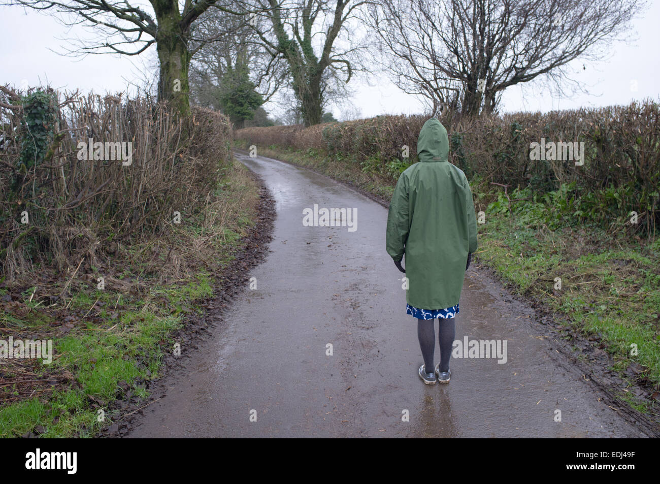 Una donna si erge su un vicolo del paese Foto Stock