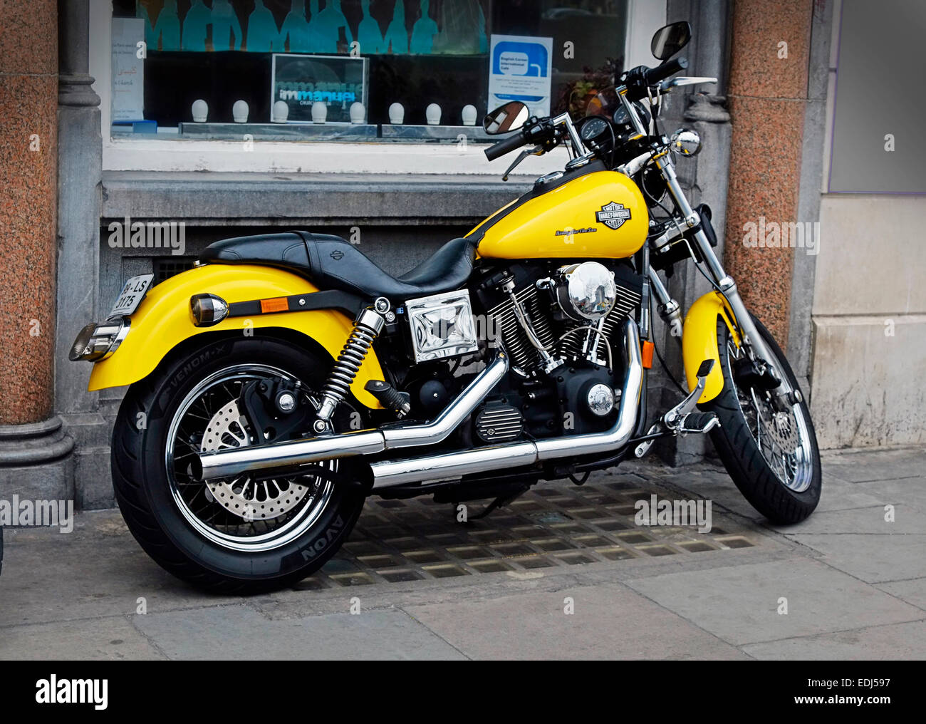 Harley Davidson Cruiser Motorcycle giallo e cromo parcheggiato su una Dublin Street Foto Stock