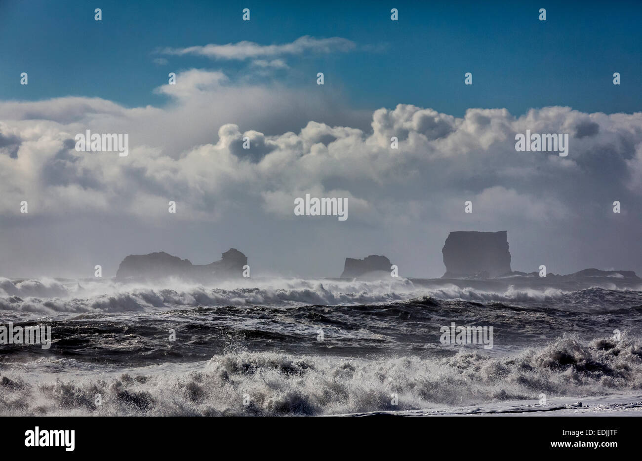 Onde che si infrangono sulla riva con Dryholaey in background, Islanda. Dyrholaey tradotto significa "il foro della porta isola " Foto Stock