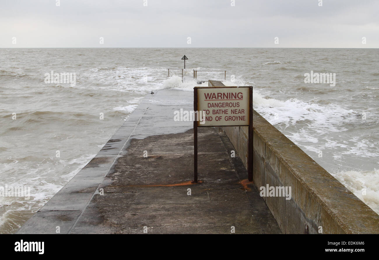 Segnale di avvertimento sulla groyne per bagnanti al mare con mare mosso in Walton-on-l'Naze, Essex Foto Stock