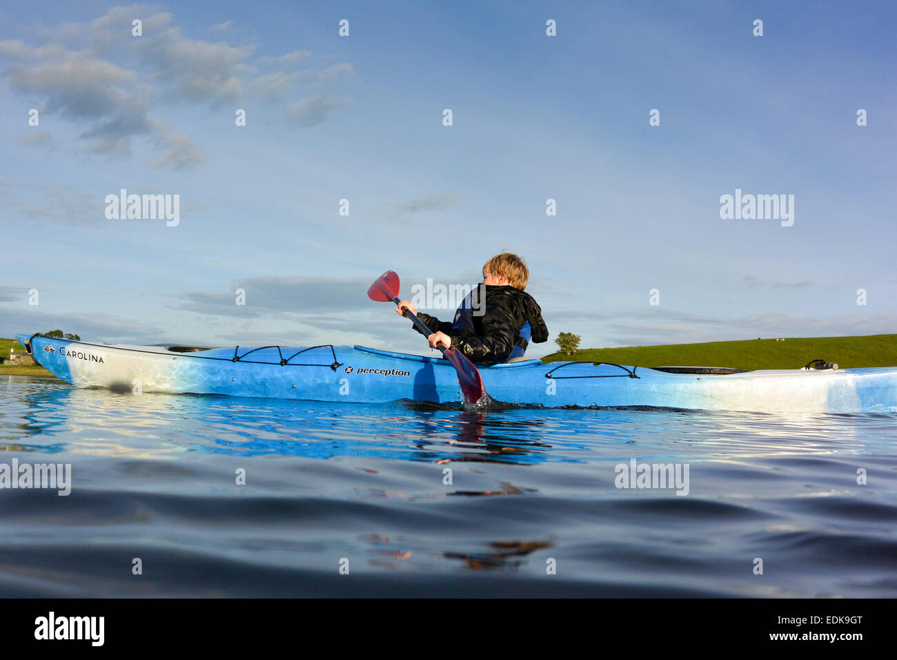 Giovane ragazzo in un kayak su Killington L:ake, Cumbria, Regno Unito Foto Stock