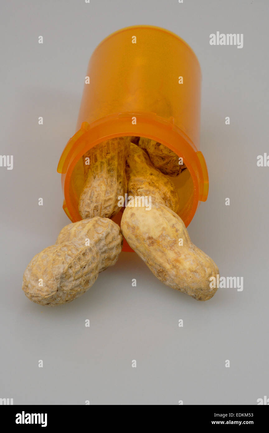 Questo stock foto mostra le Arachidi in guscio fuoriuscita dalla bottiglia di prescrizione. Foto Stock