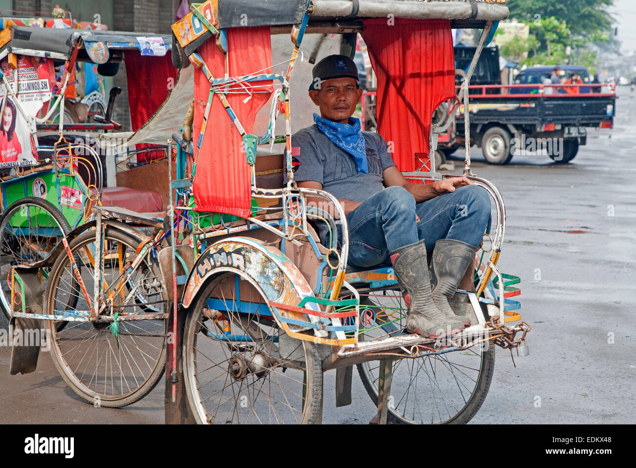 Indonesiano driver becak in attesa per i clienti nel suo ciclo rickshaw, Kota Bandung, West Java, Indonesia Foto Stock