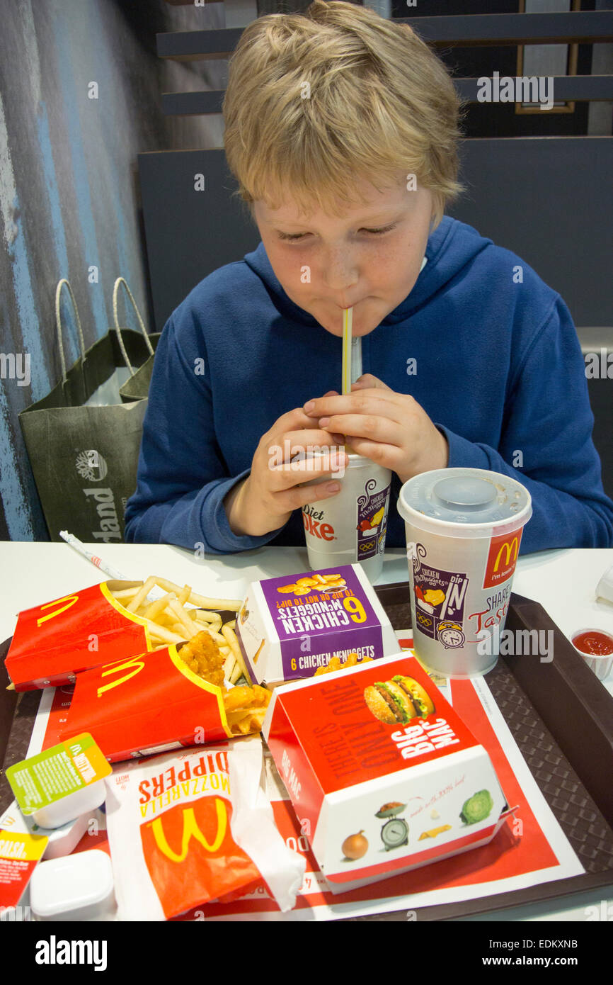 Ragazzo di mangiare in un fast food ristorante, UK. Foto Stock