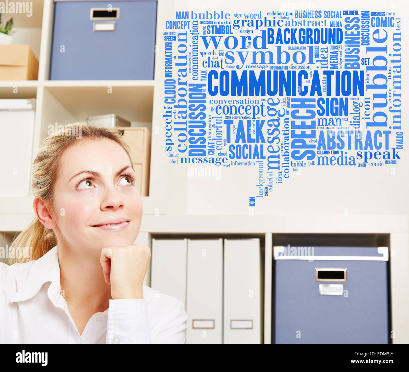 Sorridente donna di affari in ufficio con il concetto di comunicazione in una nuvola di tag Foto Stock