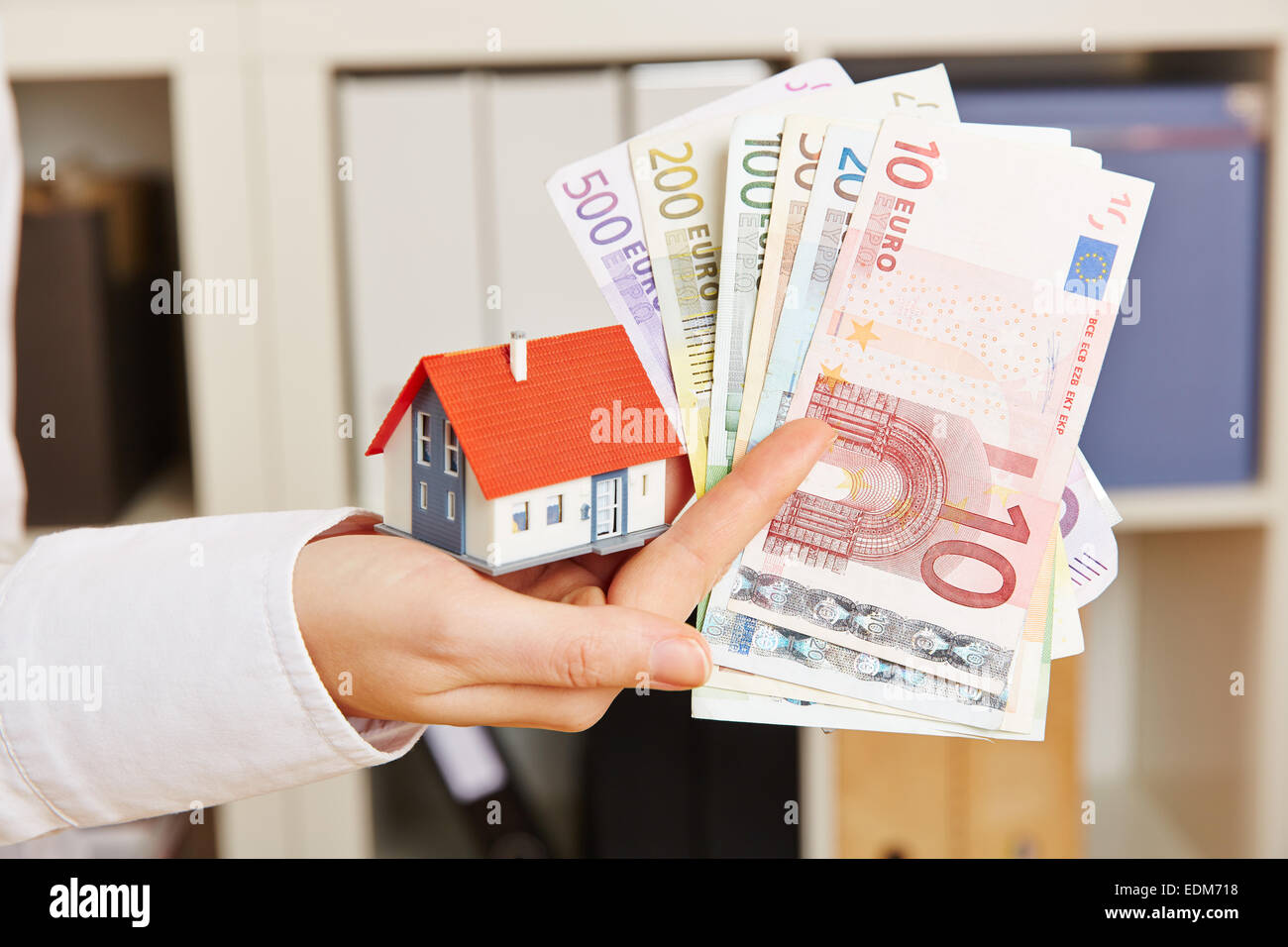 Mano azienda casa e denaro Euro come concetto di finanziamento immobiliare Foto Stock