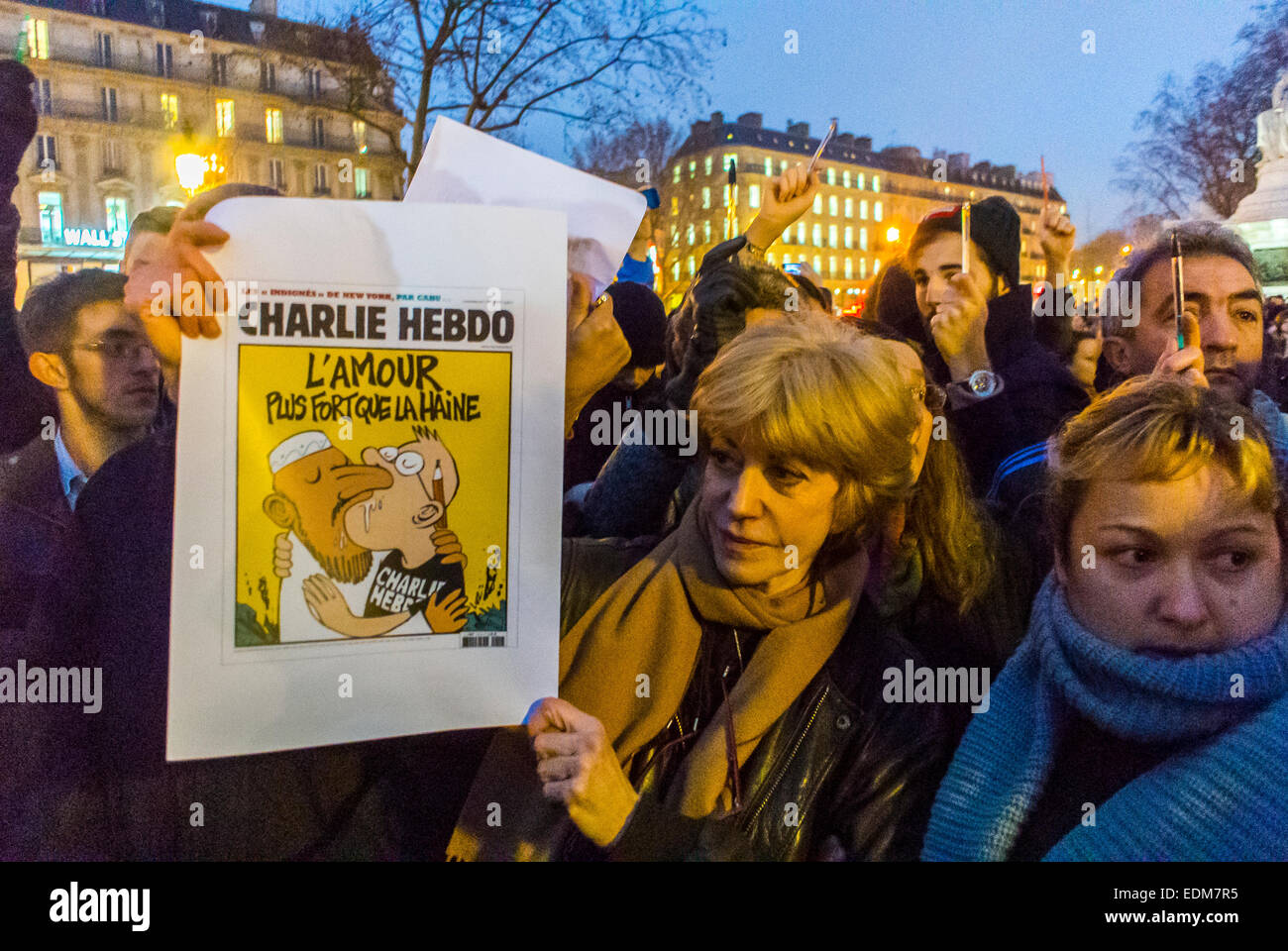 Parigi, Francia, dimostrazione contro il terrorismo, dopo aver sparato un attacco terroristico al giornale francese, Charlie Hebdo, donna che tiene una copertina di carta. Notte, dimostrazione 'je suis Charlie Paris' Paris republique Foto Stock