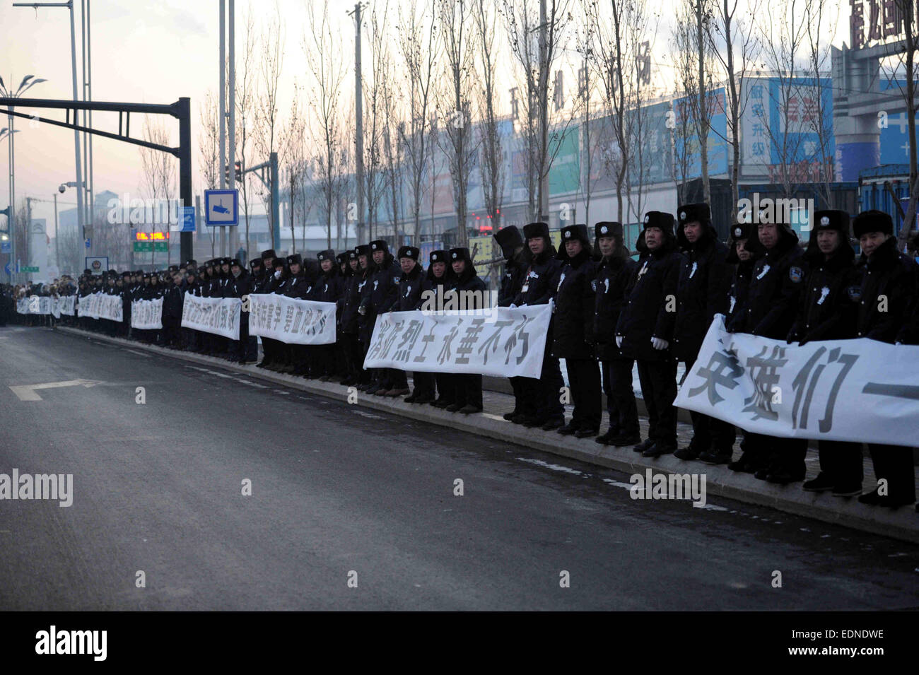 Harbin, la Cina della Provincia di Heilongjiang. 8 Gen, 2015. Poliziotti tenendo i banner di partecipare ai funerali per cinque vigili del fuoco a Harbin, capitale del nord-est della Cina di Provincia di Heilongjiang, 8 gennaio, 2015. Un grave incendio scoppiato in un magazzino a gennaio 2 a Harbin che ha ucciso cinque vigili del fuoco. Del defunto vigili del fuoco, il più giovane aveva 18 anni e il più antico 22. © Wang Song/Xinhua/Alamy Live News Foto Stock