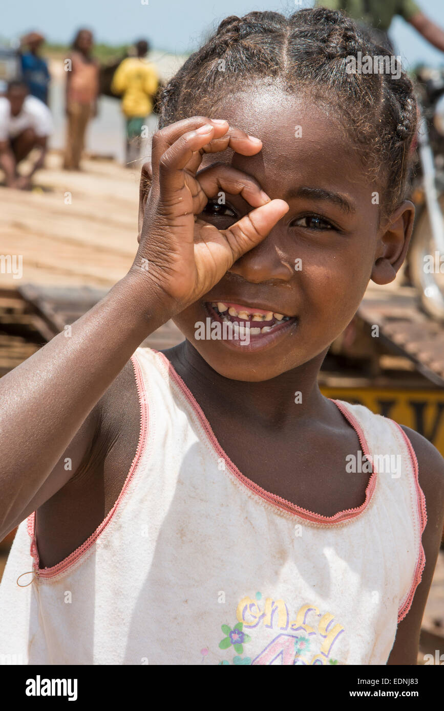 Ragazza 6 anni, guardando attraverso le sue dita, Belo-sur-Tsirihibina, Madagascar Foto Stock