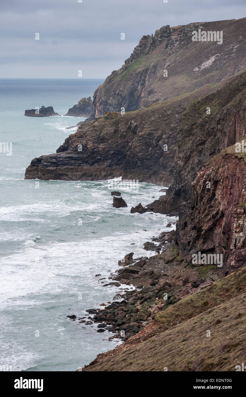 Drammatico scenario costiero vicino a Sant Agnese in North Cornwall. Imponenti scogliere rocciose con onde la rottura in corrispondenza della loro base. Foto Stock