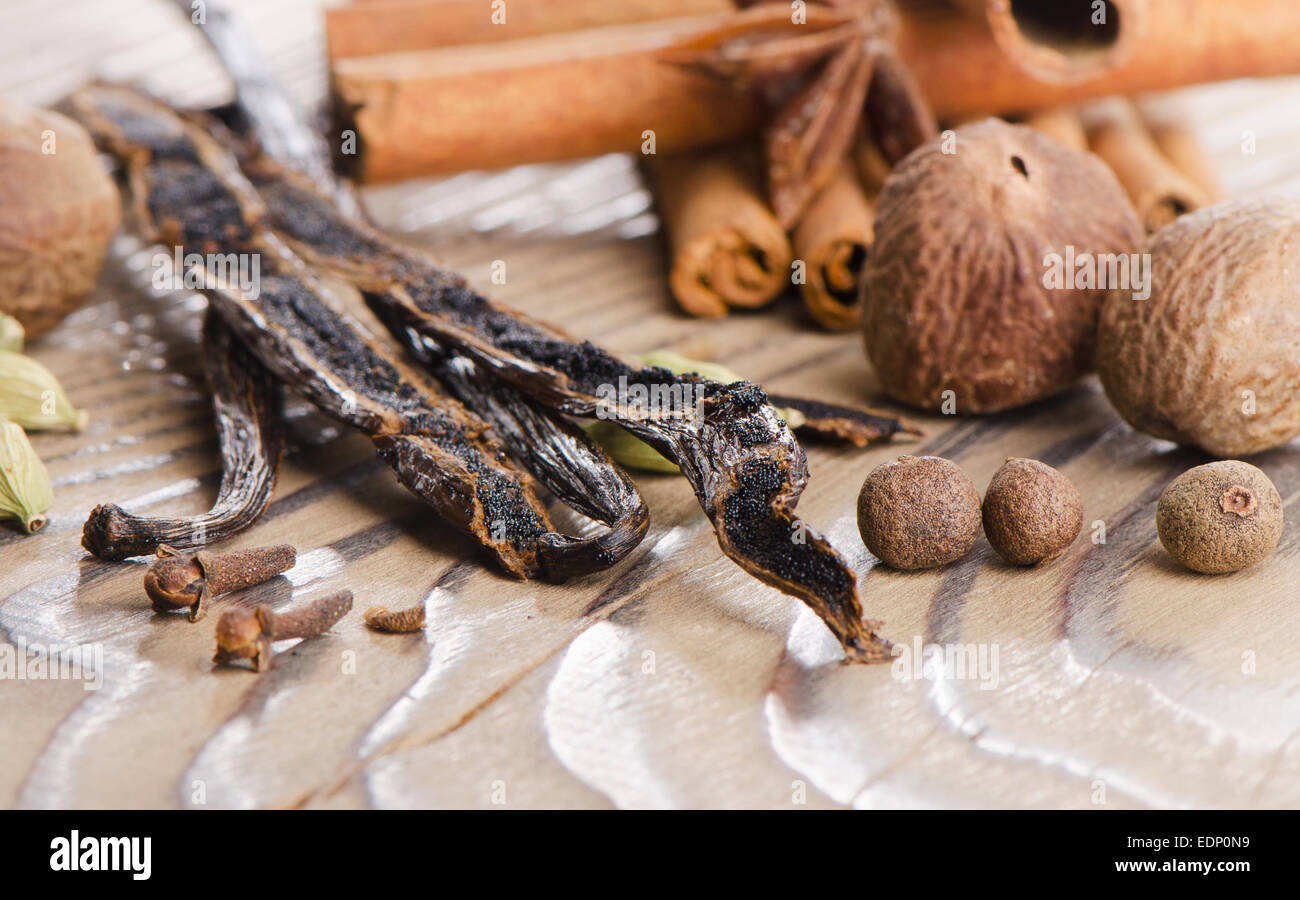 Spezie con baccelli di vaniglia su uno sfondo di legno . Messa a fuoco selettiva Foto Stock