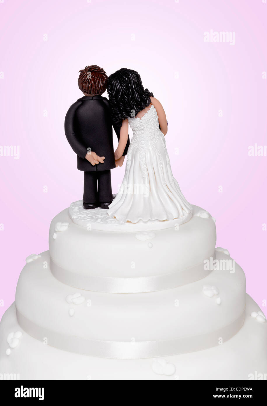 Un cake topper che mostra lo sposo incrocio le dita Foto Stock