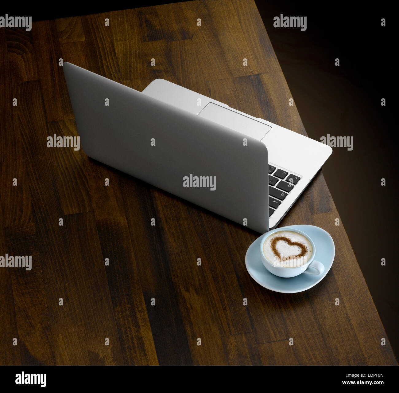 Un computer portatile e la tazza di caffè su di un tavolo di legno top Foto Stock