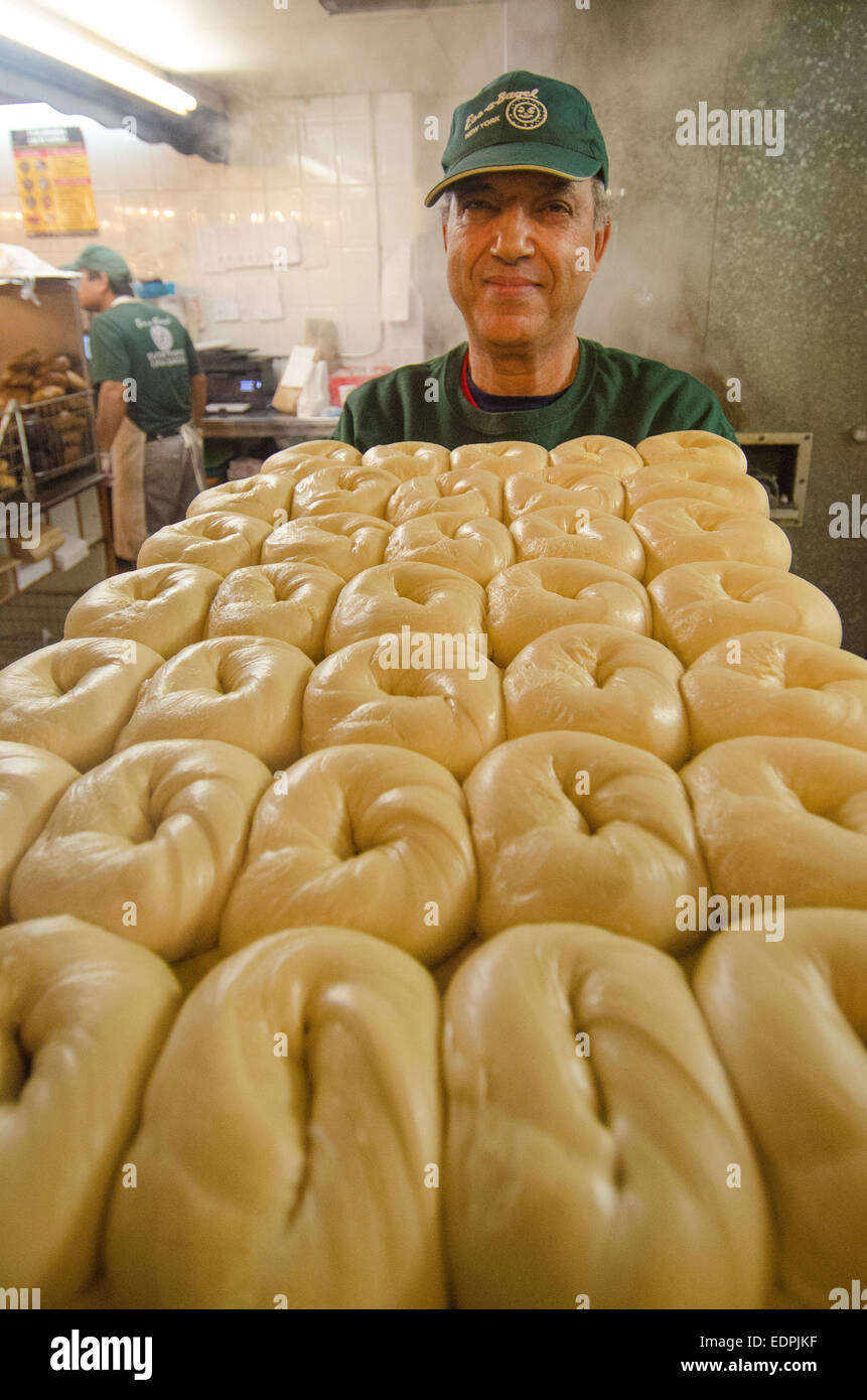 Bollitore-boiled bagel sono trasportati verso il forno per la sua fase finale di preparazione alla New York City's ess-a-Bagel. Foto Stock