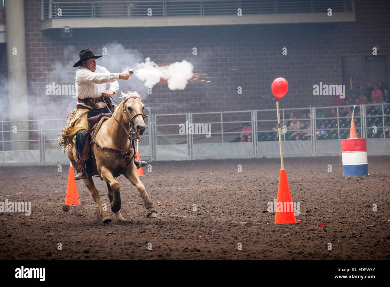 Cowboy pistola spara a bersagli di palloncino durante la ripresa montata contest. Iowa State Fair, Des Moines. Foto Stock