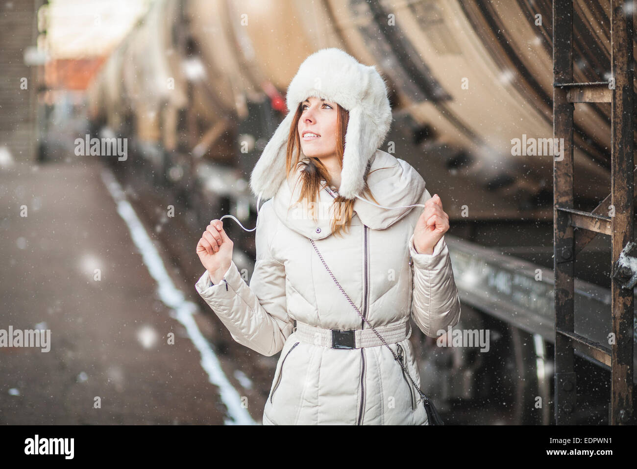 Giovane donna nel cappello di pelliccia e down jacket in prossimità del trasporto merci Foto Stock