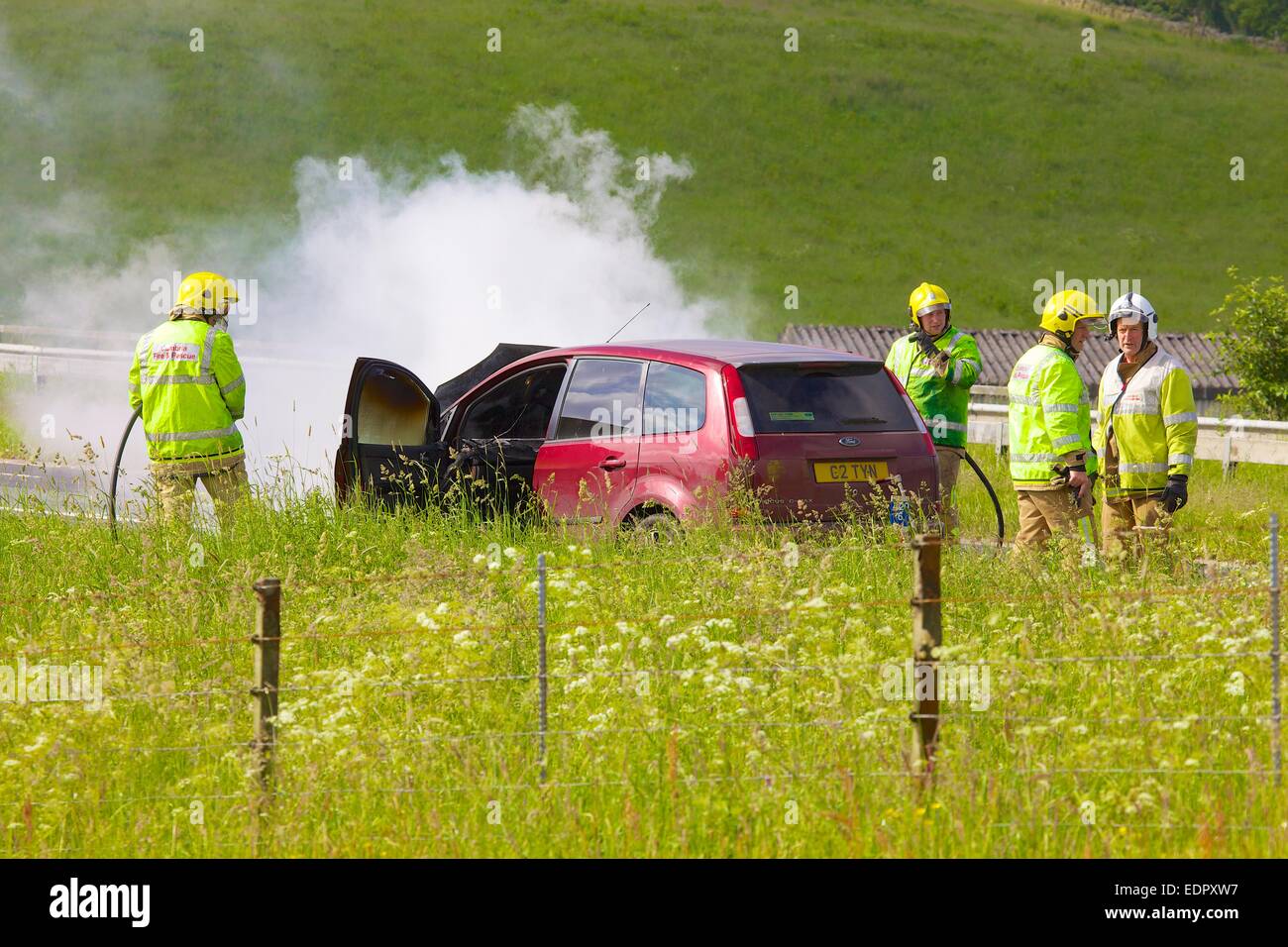 Cumbria Fire & Rescue Service ha a che fare con una macchina fuoco sulla M6. Cumbria Inghilterra England Regno Unito Foto Stock