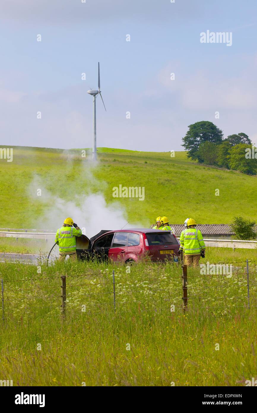 Cumbria Fire & Rescue Service ha a che fare con una macchina fuoco sulla M6. Cumbria Inghilterra England Regno Unito Foto Stock