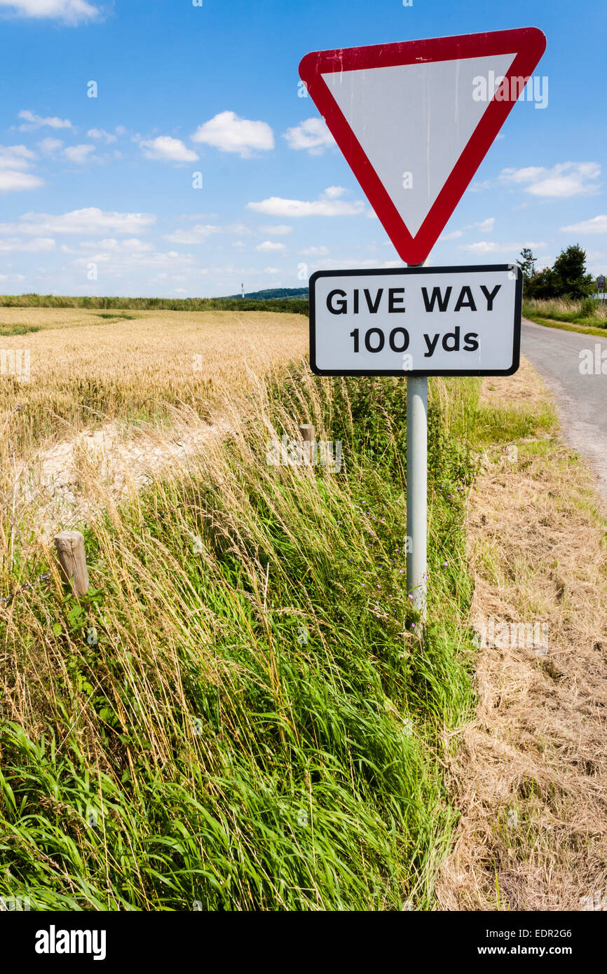Dare modo segno dal campo sulla strada rurale in Inghilterra. Foto Stock