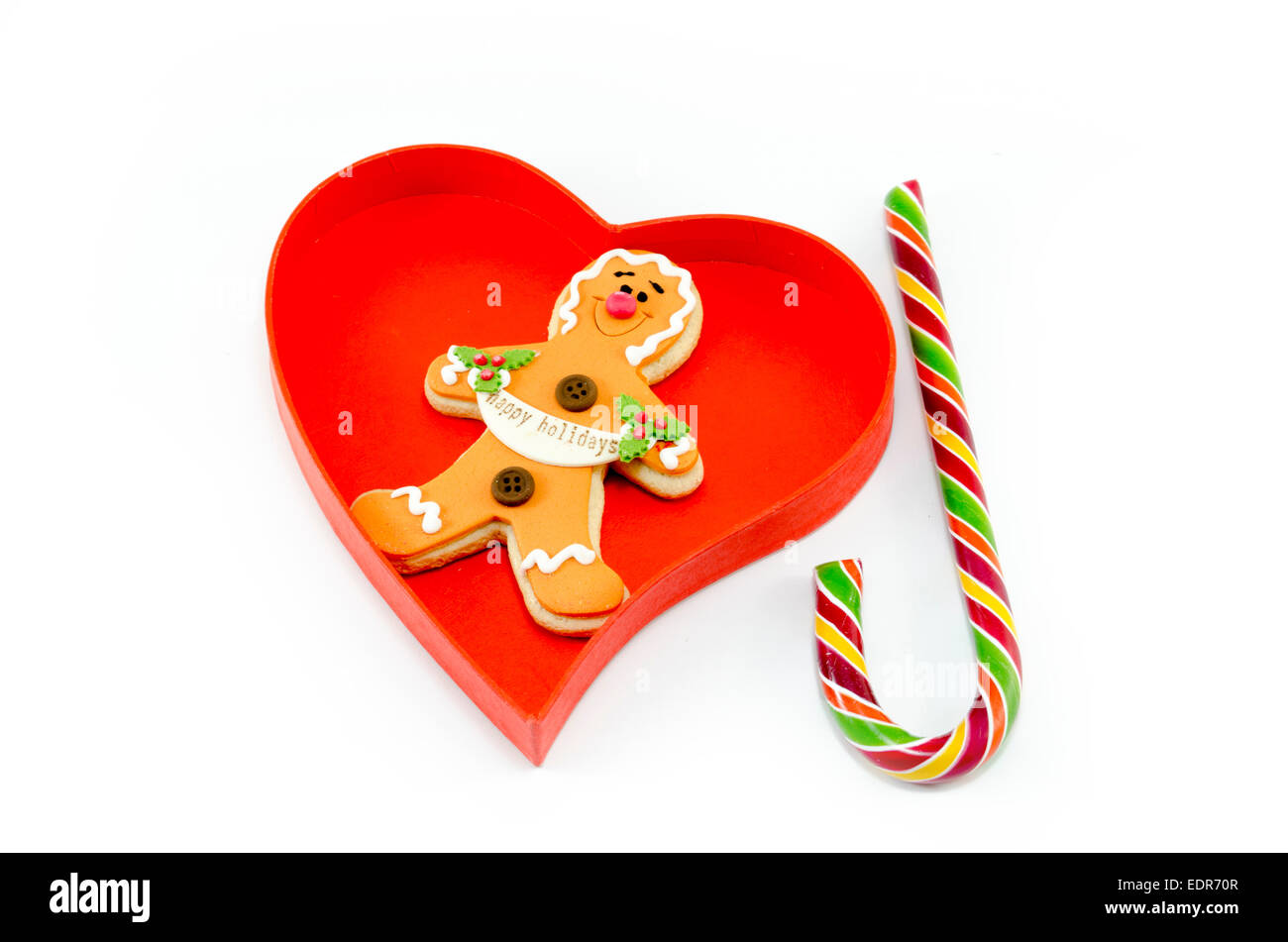 Gingerbread e un candy cane in un cuore scatola sagomata isolata su sfondo bianco Foto Stock