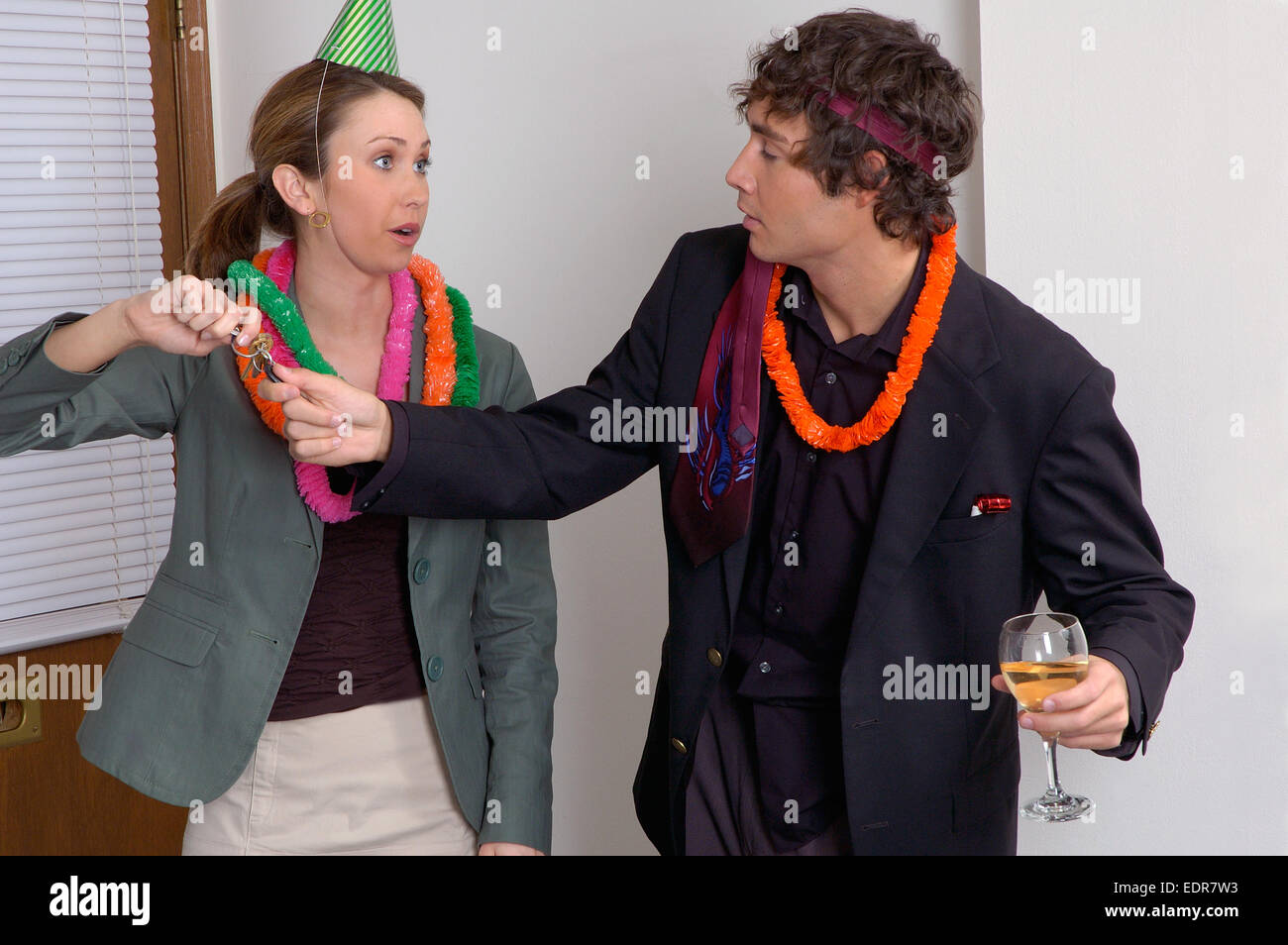 Una donna in un ufficio delle parti di prendere le chiavi dell'auto di distanza da un disheveled in cerca uomo che è stato il consumo di alcol. Foto Stock
