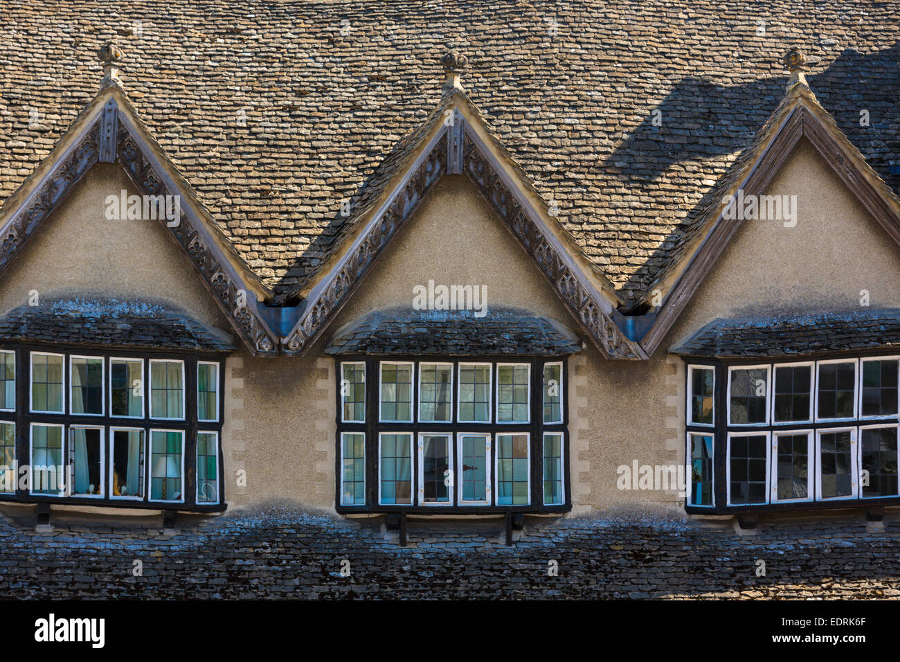 Architettura medievale finestre e tetti inclinati di edifici antichi lungo burford high street, il Costwolds, oxfordshire, Regno Unito Foto Stock