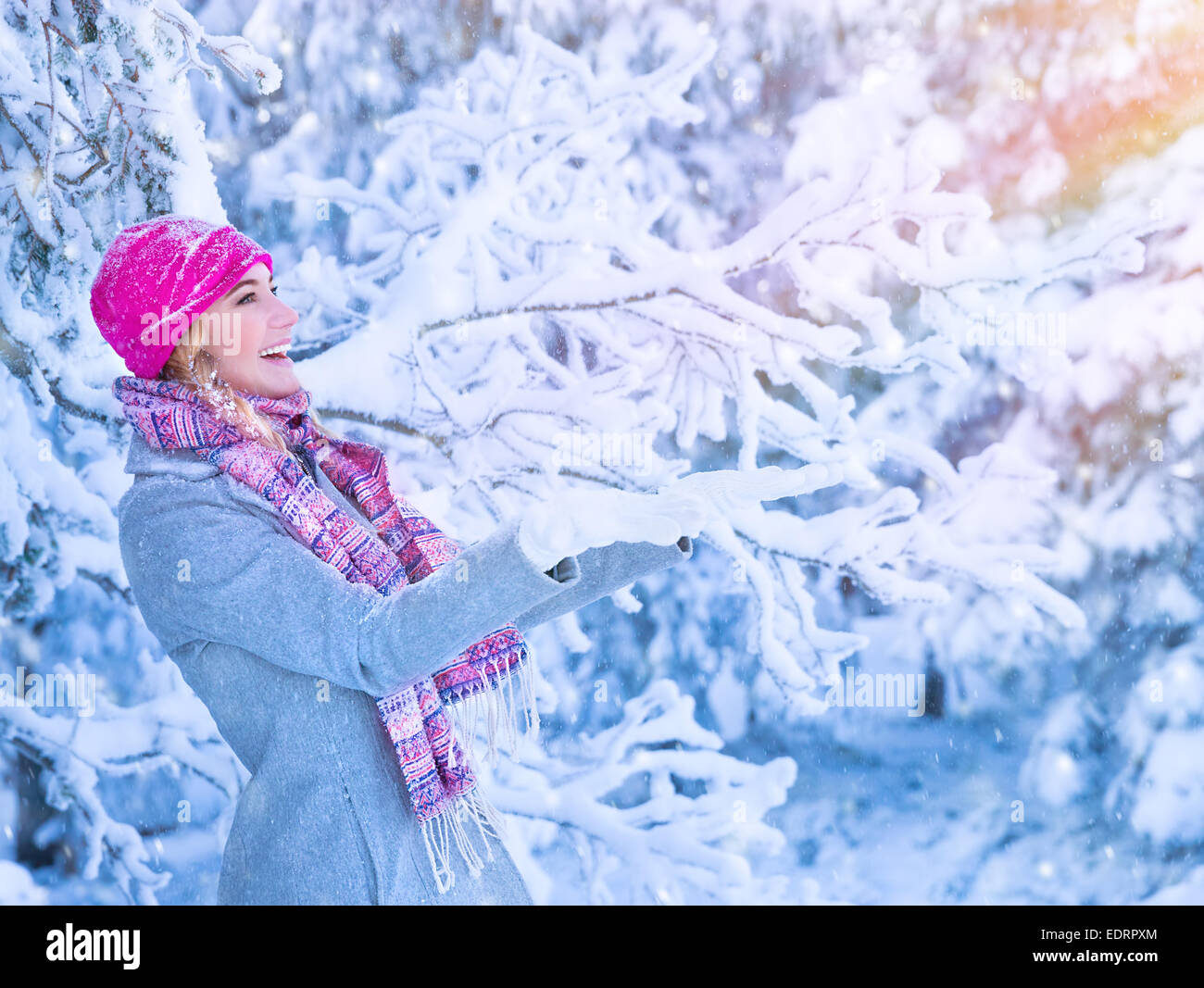 Ritratto di carina ragazza felice godendo di inverno, avendo divertimento all'aperto, si ritiene che le catture di fiocchi di neve da mani, di felicità e di attività Foto Stock