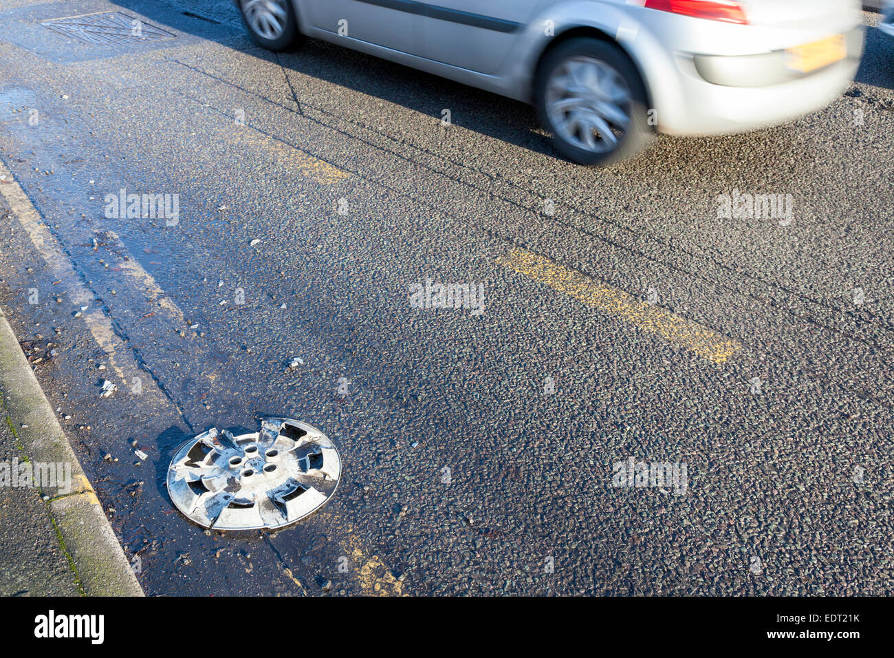 Rivestimento ruota o il coperchio sulla strada che è caduto in un auto, England, Regno Unito Foto Stock