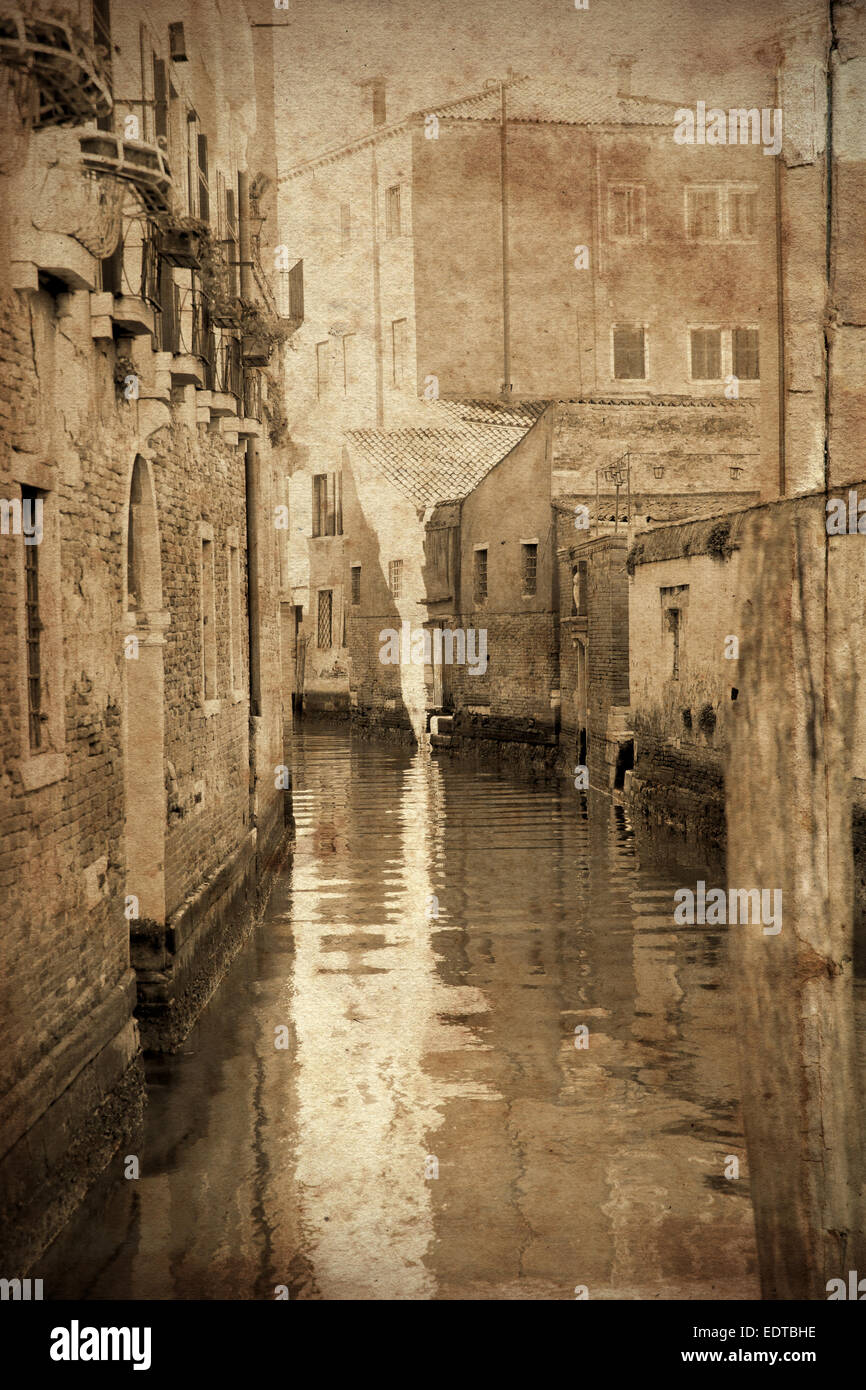 Retrò e in stile vintage vista dei canali della romantica città di Venezia, Italia. Grunge texture applicata come sfondo Foto Stock
