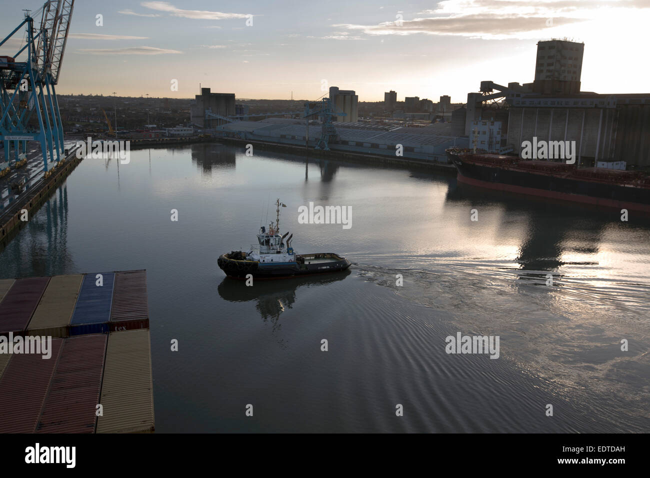 Un rimorchiatore tirando il Panama-contenitore registrata la nave MSC Sandra, all'Seaforth Dock Liverpool, in Inghilterra, Regno Unito. Foto Stock