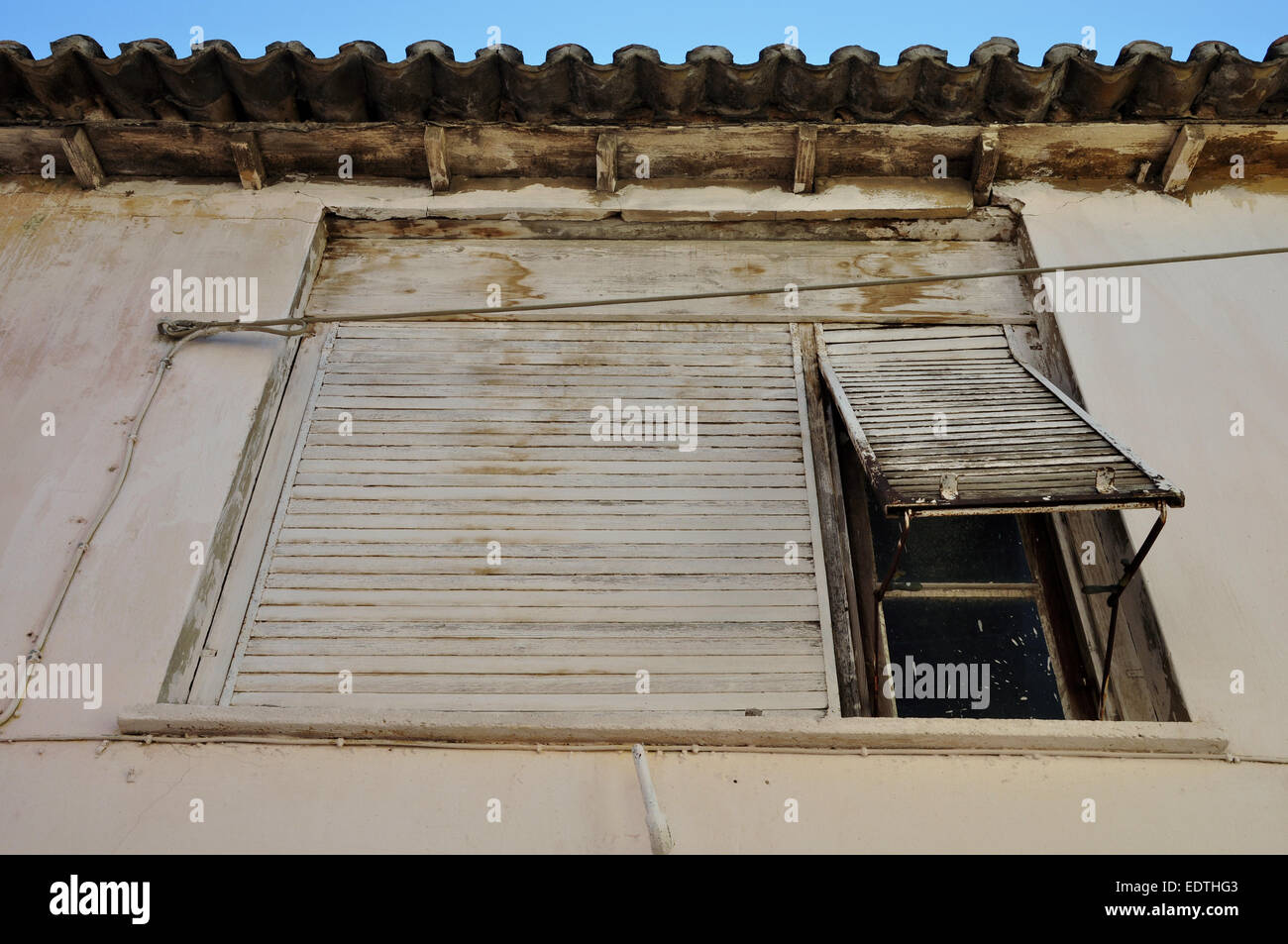Rusty persiana e colorate Pareti bianche. Casa abbandonata esterno. Foto Stock