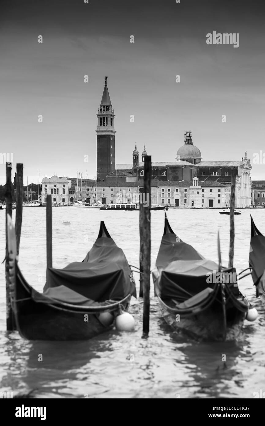 Chiesa di San Giorgio Maggiore sull'isola di San Giorgio Maggiore con gondole parcheggiato in acqua a Venezia, Italia. Foto Stock