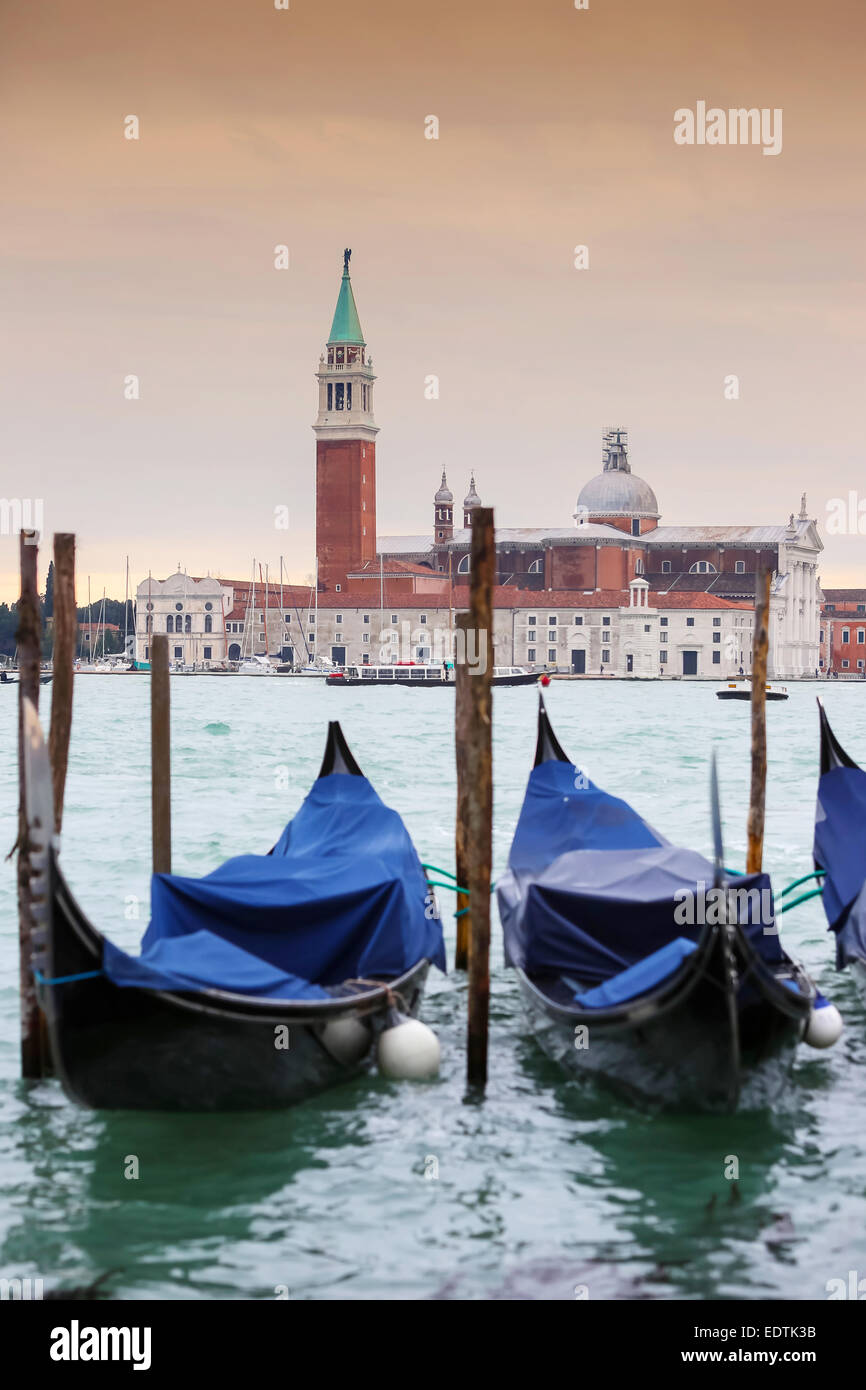 Chiesa di San Giorgio Maggiore sull'isola di San Giorgio Maggiore con gondole parcheggiato in acqua a Venezia, Italia. Foto Stock