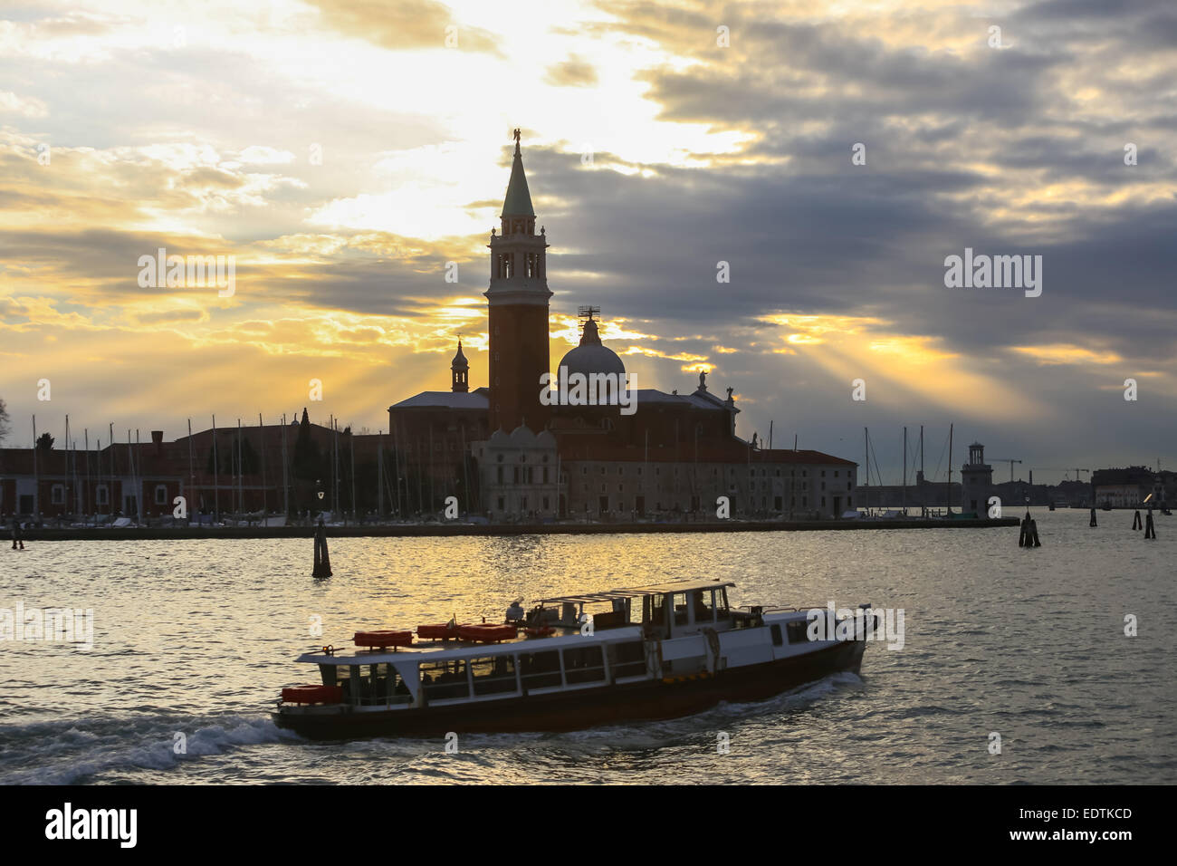 Chiesa di San Giorgio Maggiore al tramonto sull'isola di San Giorgio Maggiore e una barca con turisti di passaggio. Foto Stock